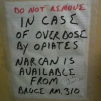 Sign indicating availability of Narcan from room 310 in case of overdose