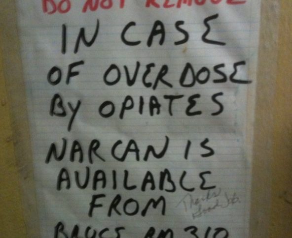 Sign indicating availability of Narcan from room 310 in case of overdose